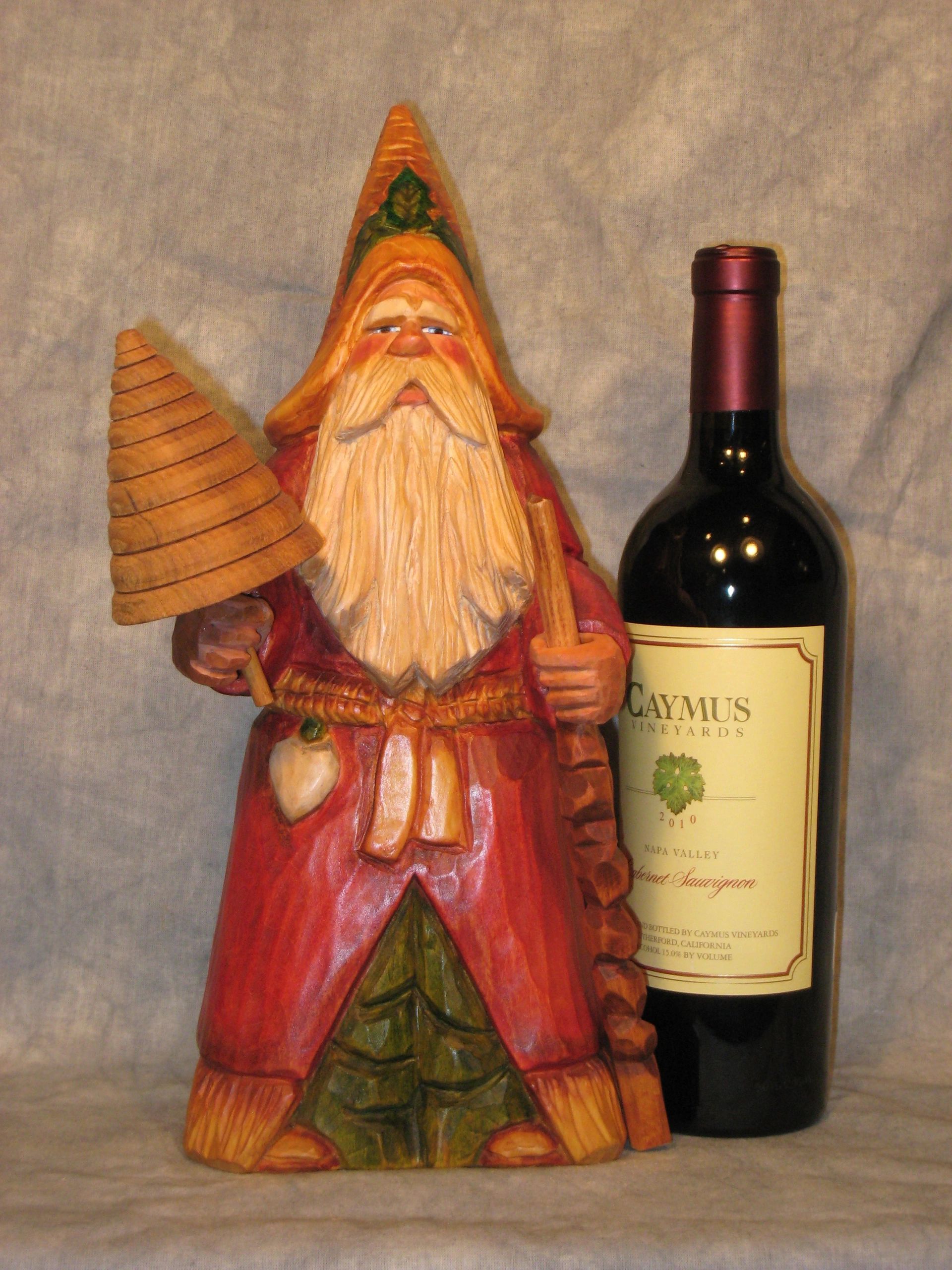 Carved wooden Santa Claus figure with wine bottle still life